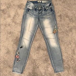 Light wash jeans with flower stitch design.
